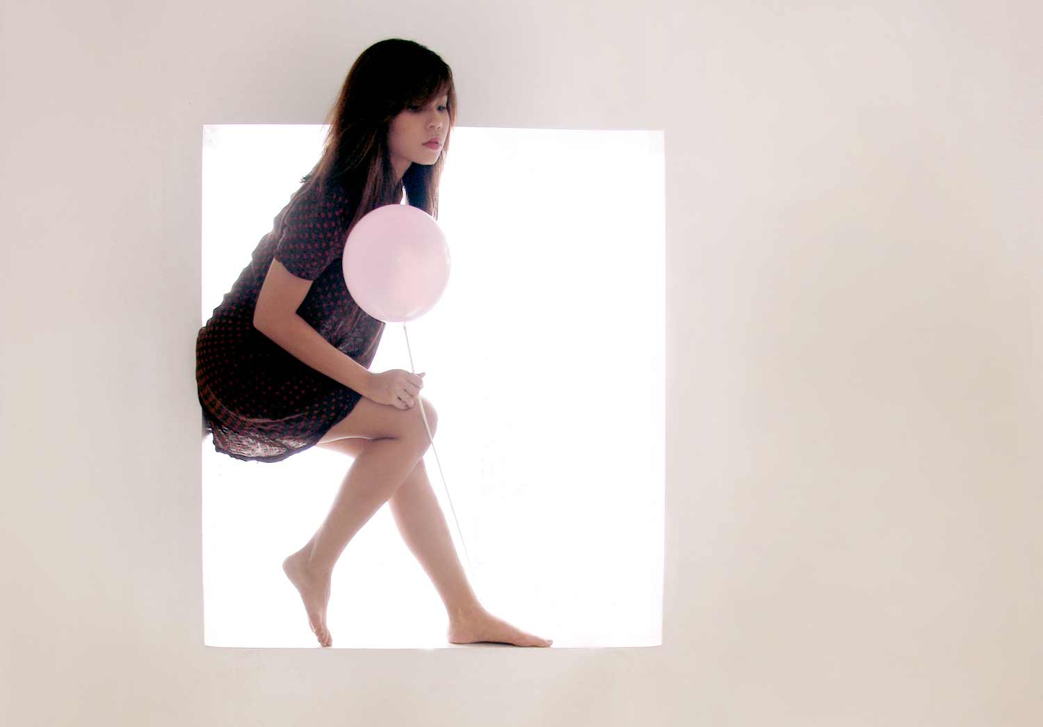 Photograph of a girl framed in a backlit window